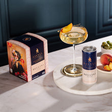 Box and can of Savyll non-alcoholic Bellini cocktail with a glass garnished with a peach slice on a marble surface.