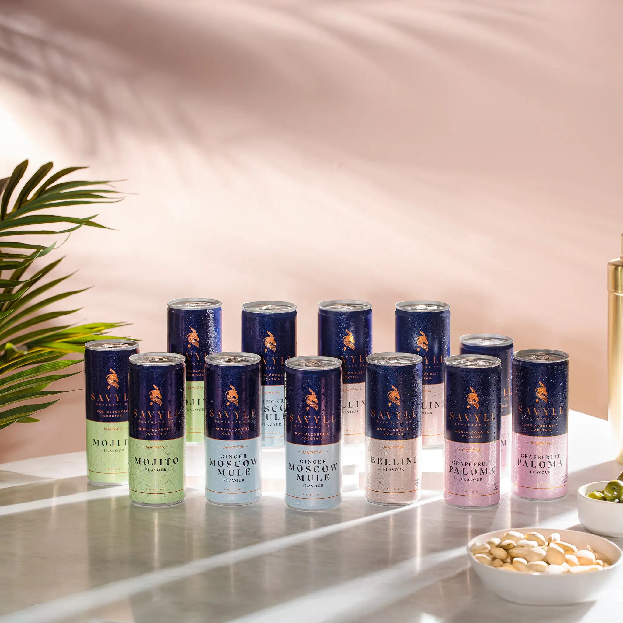 Twelve-pack of Savyll alcohol-free cocktails in Mojito, Ginger Moscow Mule, Bellini, and Grapefruit Paloma flavors on a marble surface.